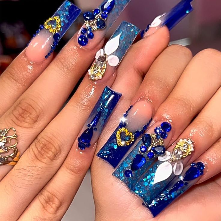 Elegant Blue Acrylic Nail Design with Sparkling Gems and Unique Textures.