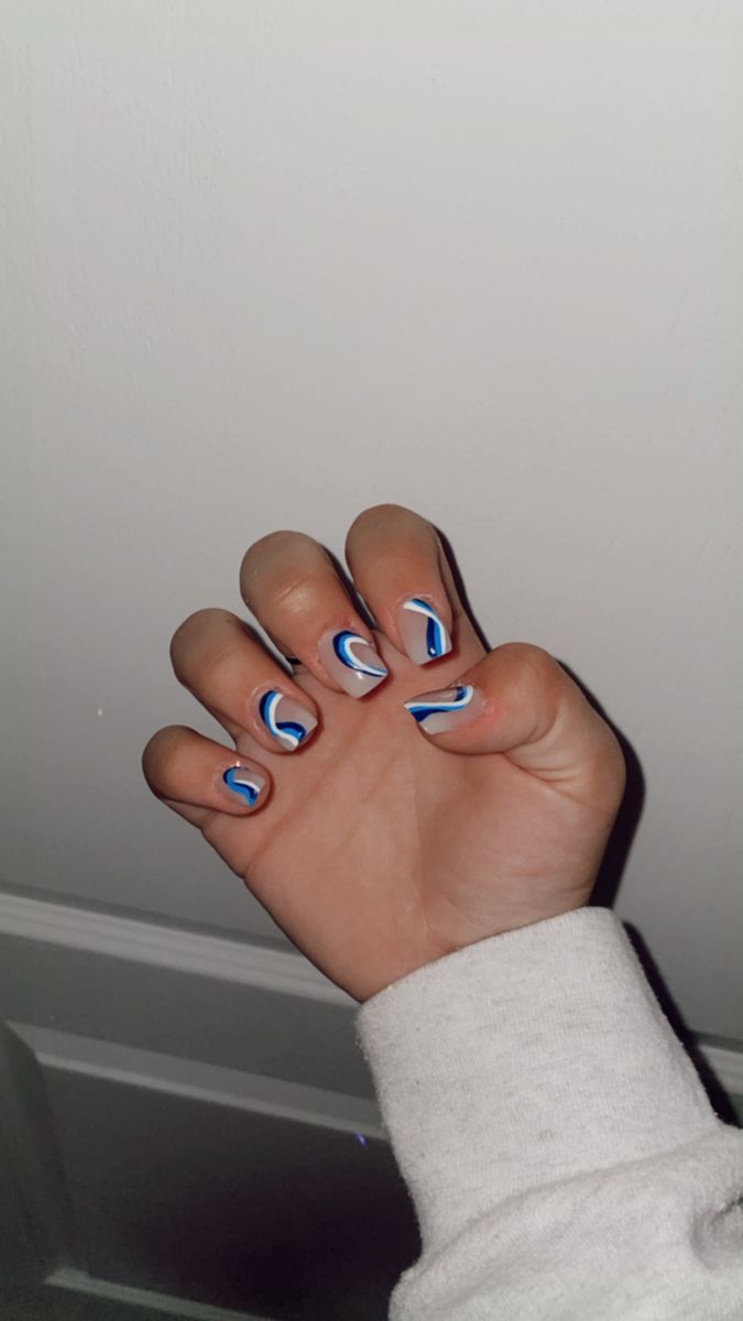 Dynamic Wave-Inspired Nail Design in Blue, White, and Black.