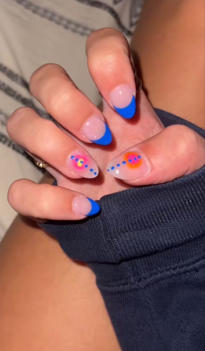 Chic Nail Design with Playful Blue Tips, Soft Pink Bases, and Whimsical Colorful Dots.