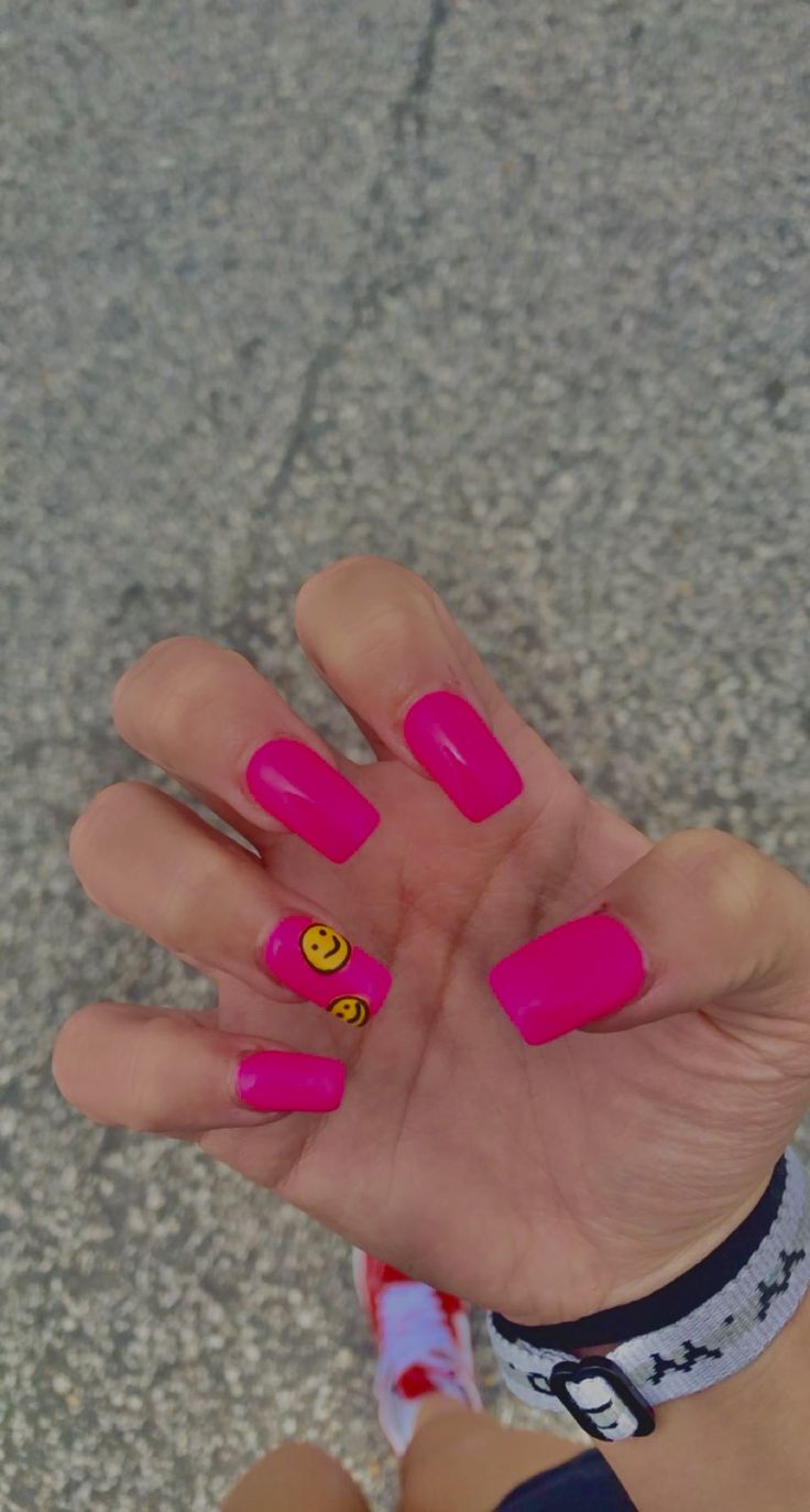 Vibrant Pink Nail Design with Playful Smiley Face Accent for a Bold Statement.