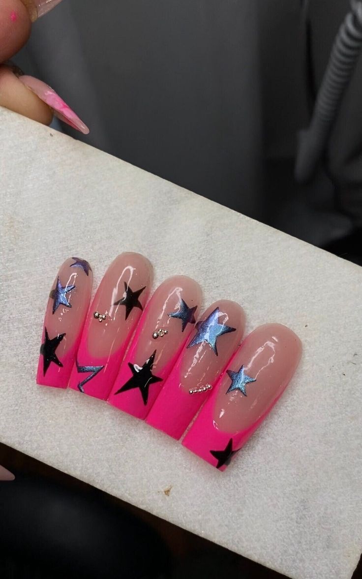 Vibrant Pink Nail Design with Striking Black and Silver Stars and Metallic Accents.