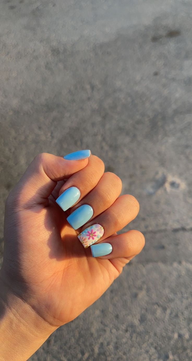 Whimsical Pastel Blue Manicure with Delicate Floral Accent Nail.