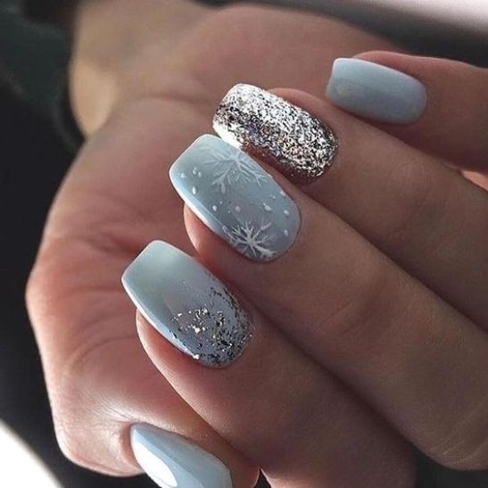 Elegant Winter-Themed Nail Design with Soft Blue and Snowflake Patterns.