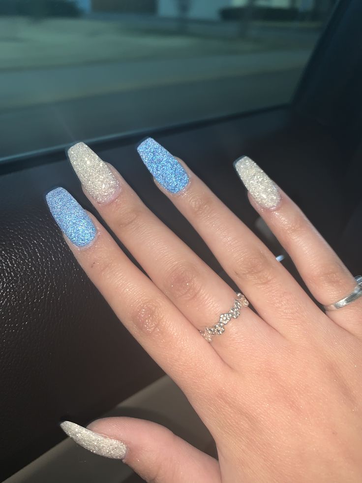 Elegant Stiletto Nail Design with Sparkling Gradient in Blue and Silver.