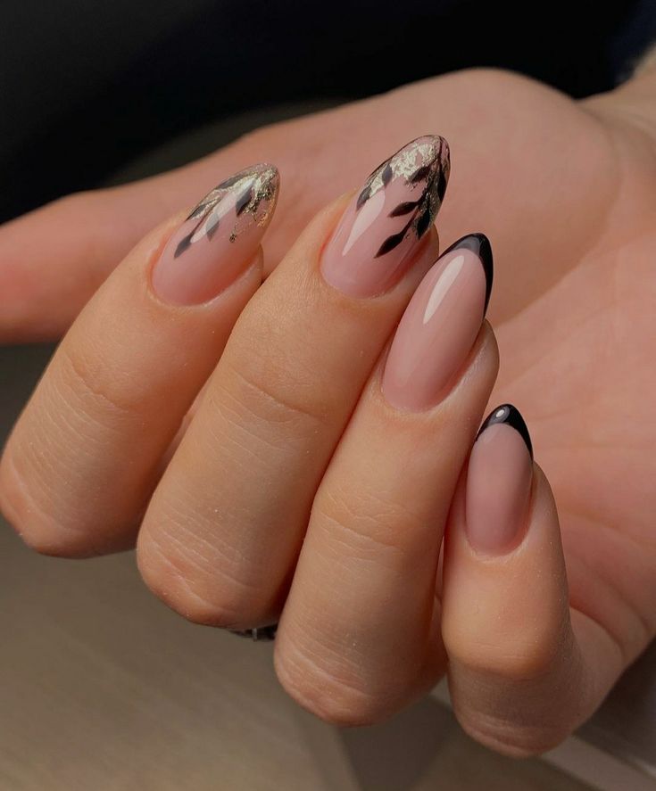 Chic Almond-Shaped Nails: Nude Base with Black Tips and Floral Accents.