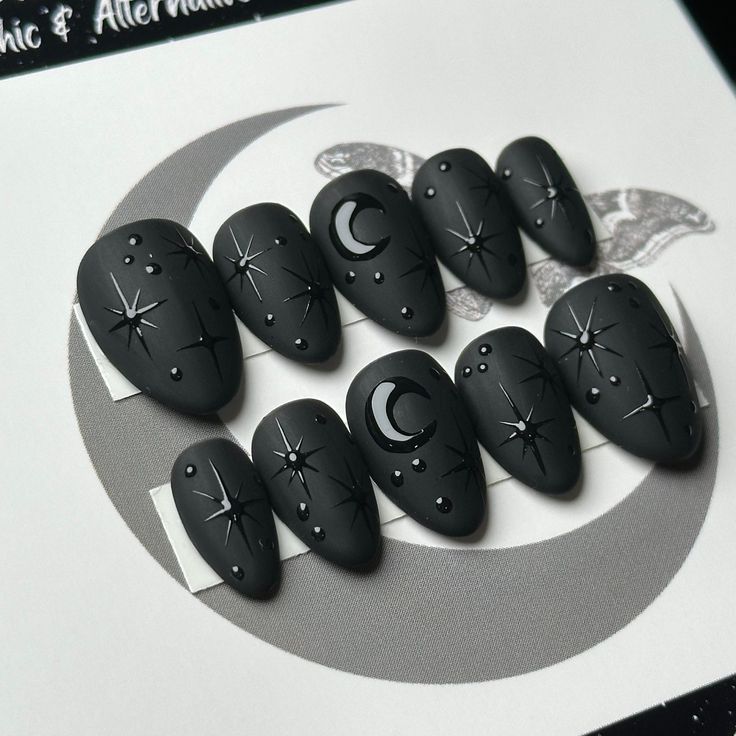 Celestial-Inspired Matte Black Nail Design with Glossy Accents and Unique Textures