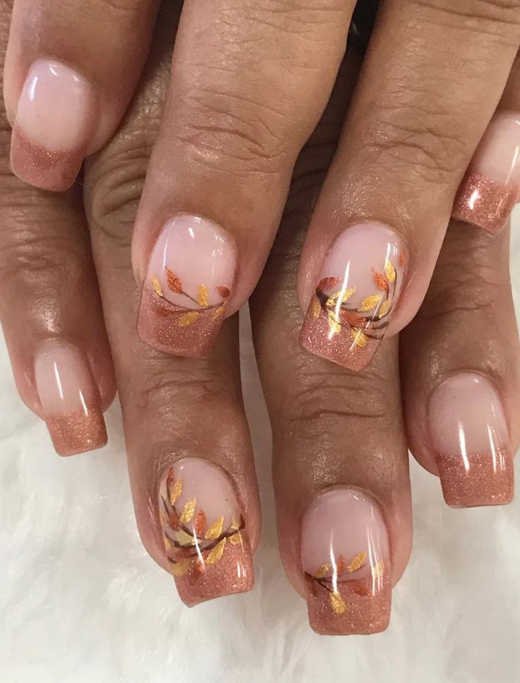 Sophisticated Nail Design: Subtle Nude to Shimmering Rose Gold Gradient with Autumn Leaf Motifs.