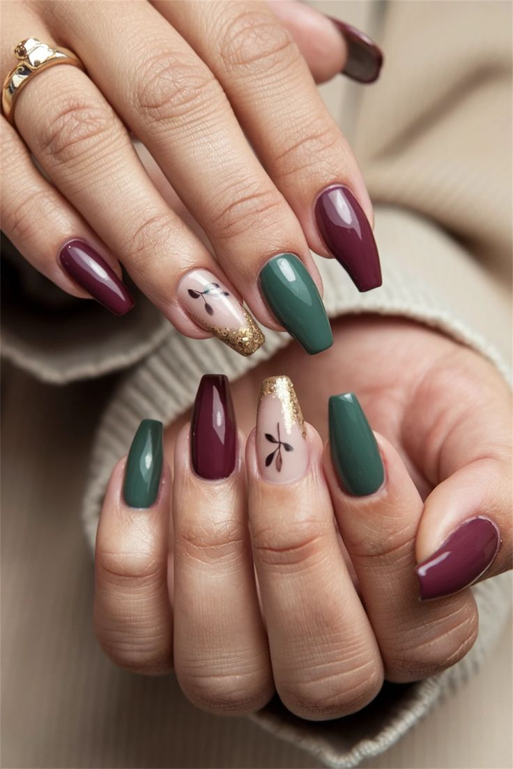 Sophisticated Nail Design: Deep Burgundy & Lush Green with Gold Accents and Floral Patterns.