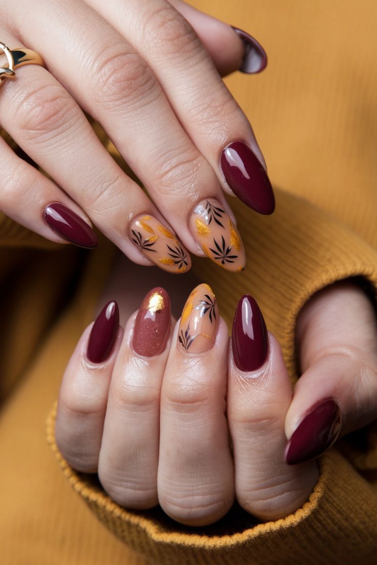 Sophisticated Autumn-Inspired Nail Design with Deep Burgundy and Intricate Leaf Patterns.