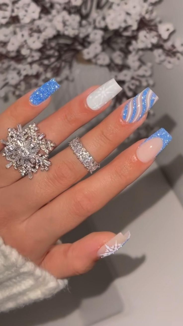 Elegant Winter-Themed Nail Art: Icy Blue and White with Glitter and Snowflake Designs