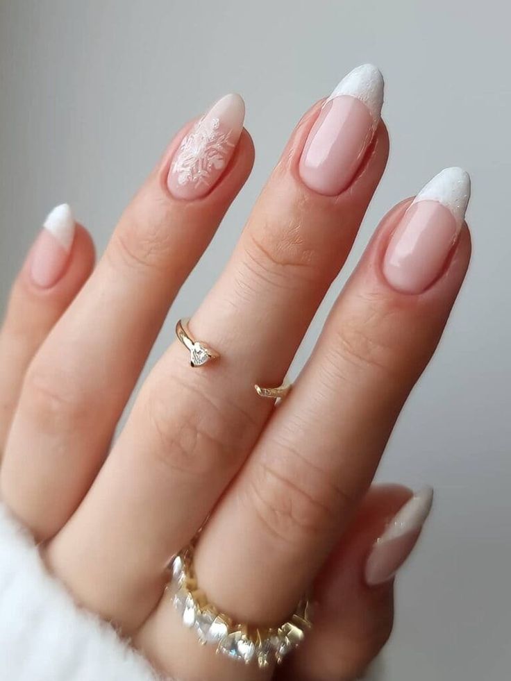 Sophisticated Nude and White Nail Design with Floral Accent and Minimalist Ring Pairing.