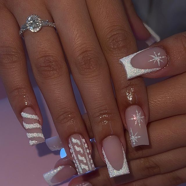 Chic Winter Nail Design: Soft Nude Base with White Accents and Snowflake Details.