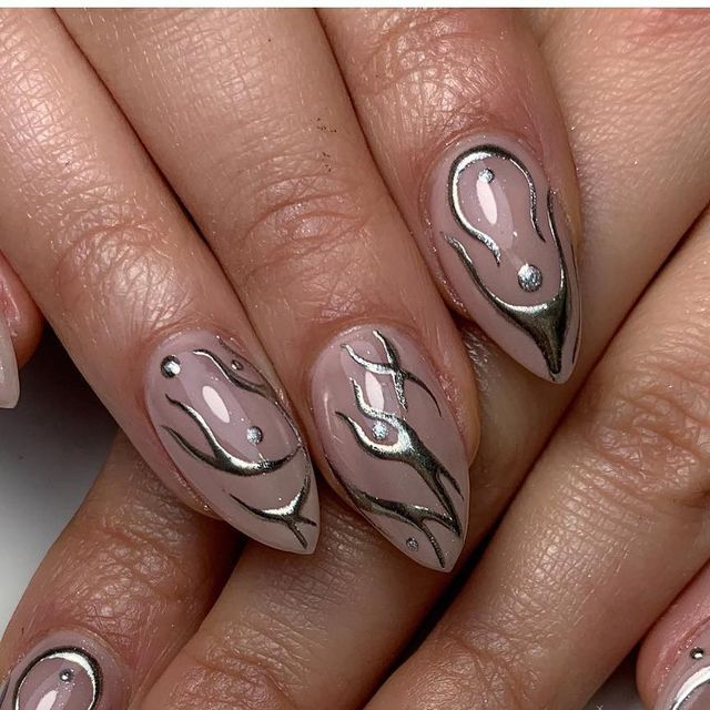 Sophisticated Nude Nail Design with Metallic Silver Accents and Abstract Shapes.