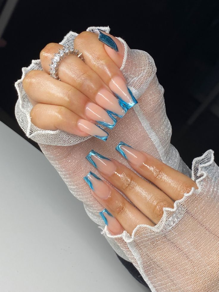 Chic Almond-Shaped Nails with Nude Base and Vibrant Blue Accents.