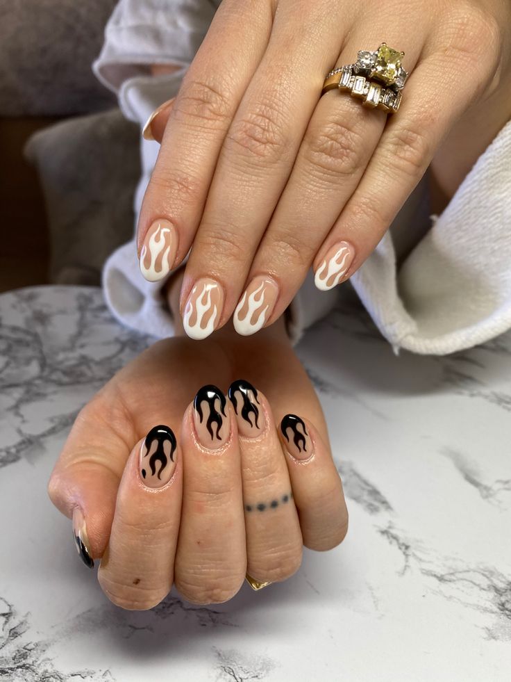 Chic Flame-Inspired Nail Design: Nude, White, and Bold Black Accents.