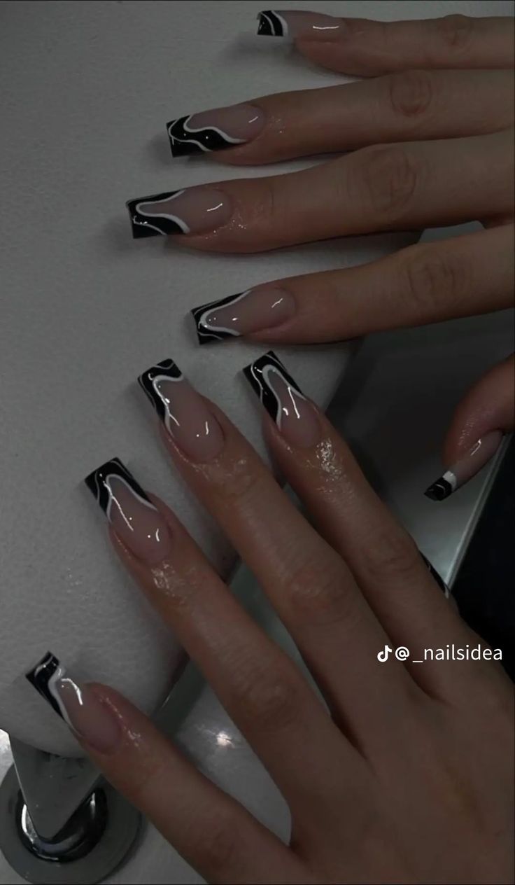 Chic Nude and Black Swirled Nail Design with Glossy Finish and Bold Tips.