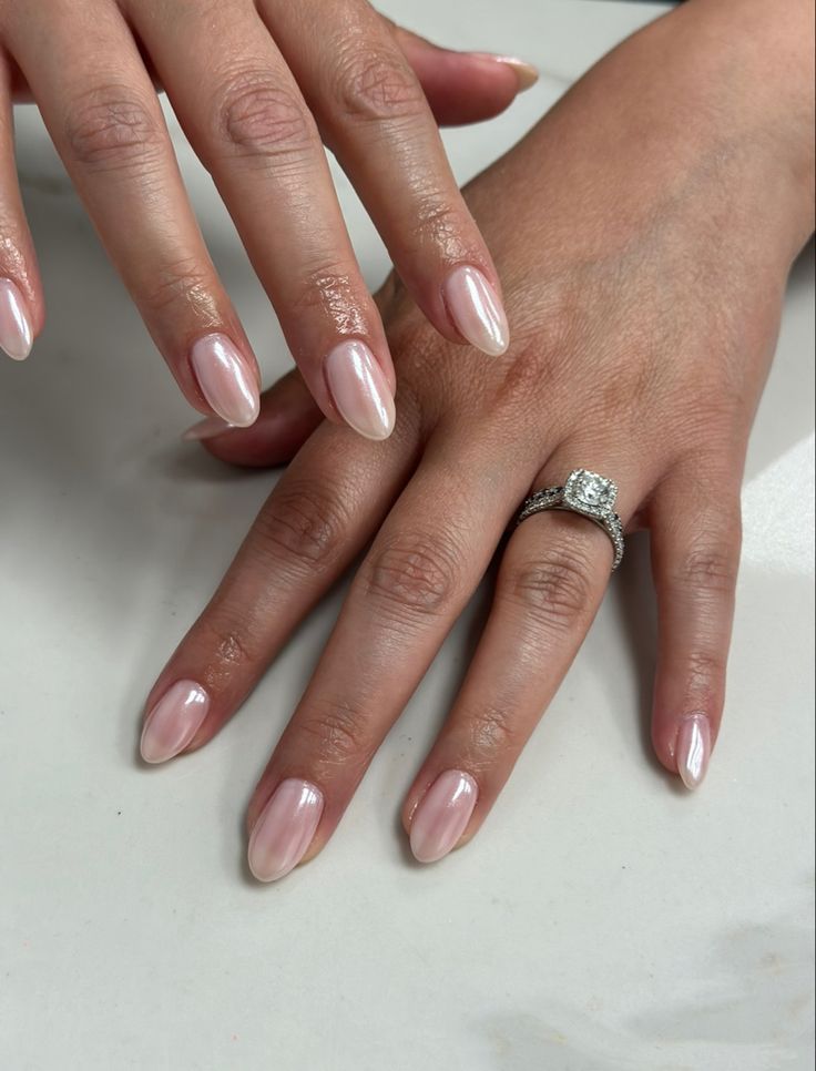 Elegant Almond-Shaped Nail Design in Soft Pink with Glossy Finish and Sparkling Ring Accent.