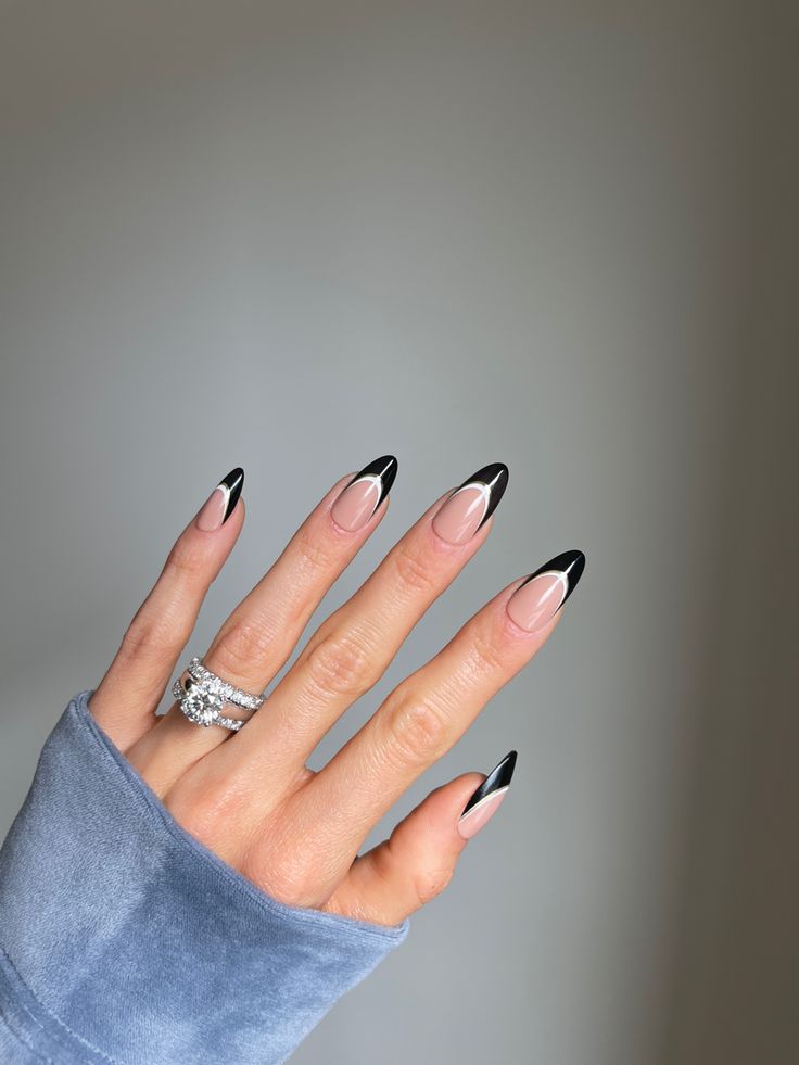 Sophisticated Nail Art: Nude Base with Bold Black Tips and Glamorous Rings