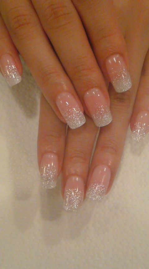 Glamorous Ombre Nails: Soft Nude Base with Shimmering Silver Tips and Glitter Accents.