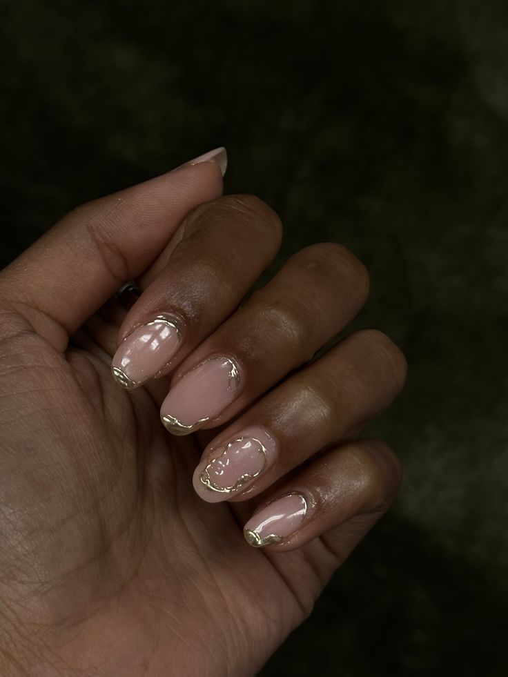 Sophisticated Nude Nail Design with Gold Accents and Geometric French Tips