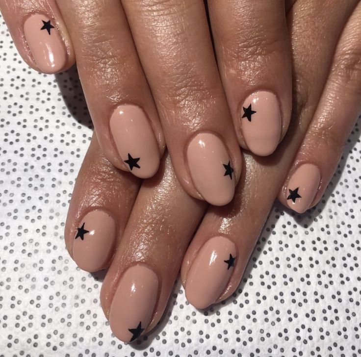 Chic Minimalist Nude Nails with Playful Black Star Accents.