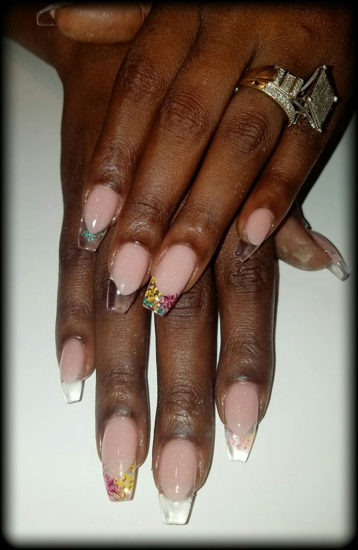 Elegant Nude and Clear Nail Design with Colorful Floral and Geometric Accents.