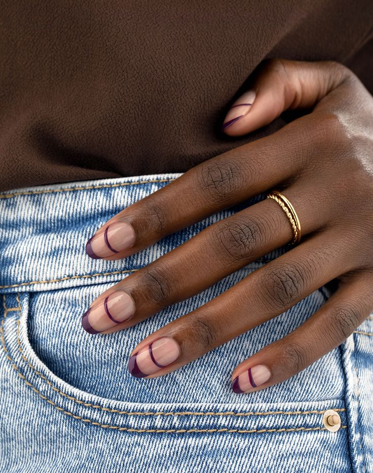 Stylish Nude and Deep Purple Nail Design with Modern Geometric Patterns.