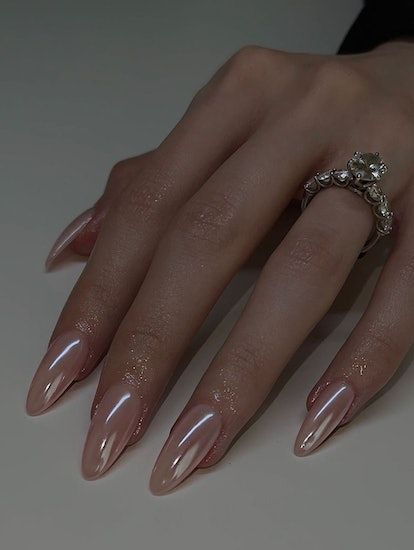 Chic Glossy Almond-Shaped Nude Nails Enhance Elegance with Stylish Ring.