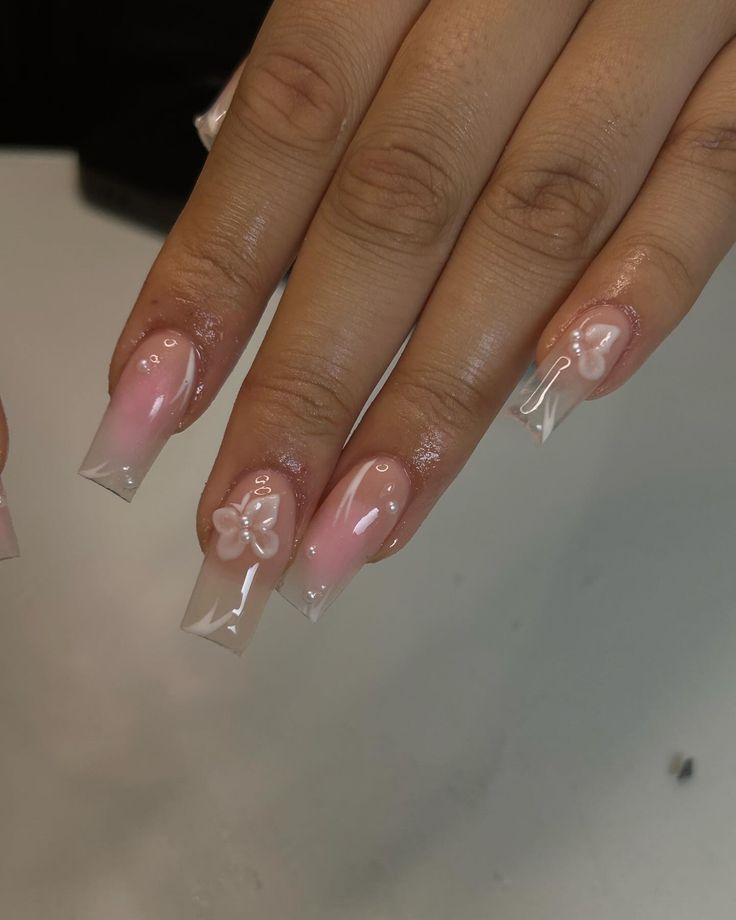 Elegant Ombre Nail Design with Floral Accents and Glossy Finish.