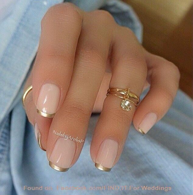 Sophisticated Elegant Nude Manicure with Gold-Tipped French Tips and Stylish Rings