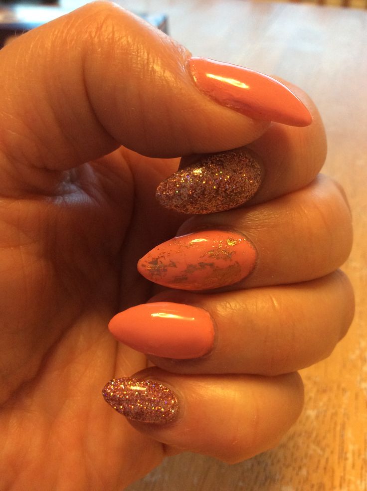 Chic Coral and Gold Almond Nail Design: Elegance Meets Playful Sparkle.