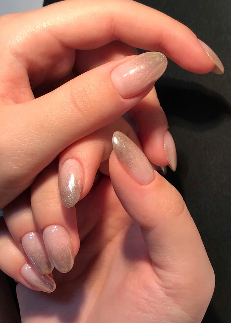 Elegant Soft Ombre Almond Nails with Glittery Nude Tones for a Chic Look.