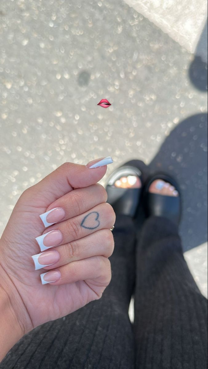 Sophisticated French Manicure with Heart Accent and Chic Casual Footwear.