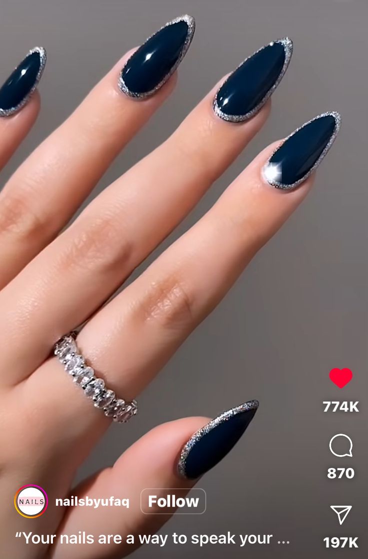 Chic Stiletto Nails: Deep Navy Polish with Shimmering Silver Tips and Elegant Ring Accent.