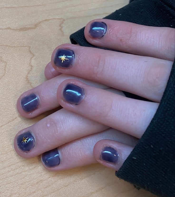 Chic Deep Purple Nail Design with Glossy Finish and Gold Star Accents.