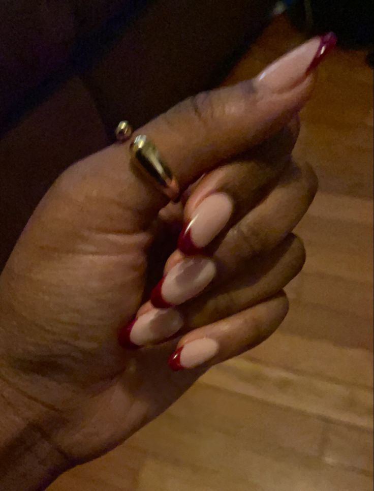 Sophisticated French Manicure: Elegant Nude Base with Striking Red Tips.