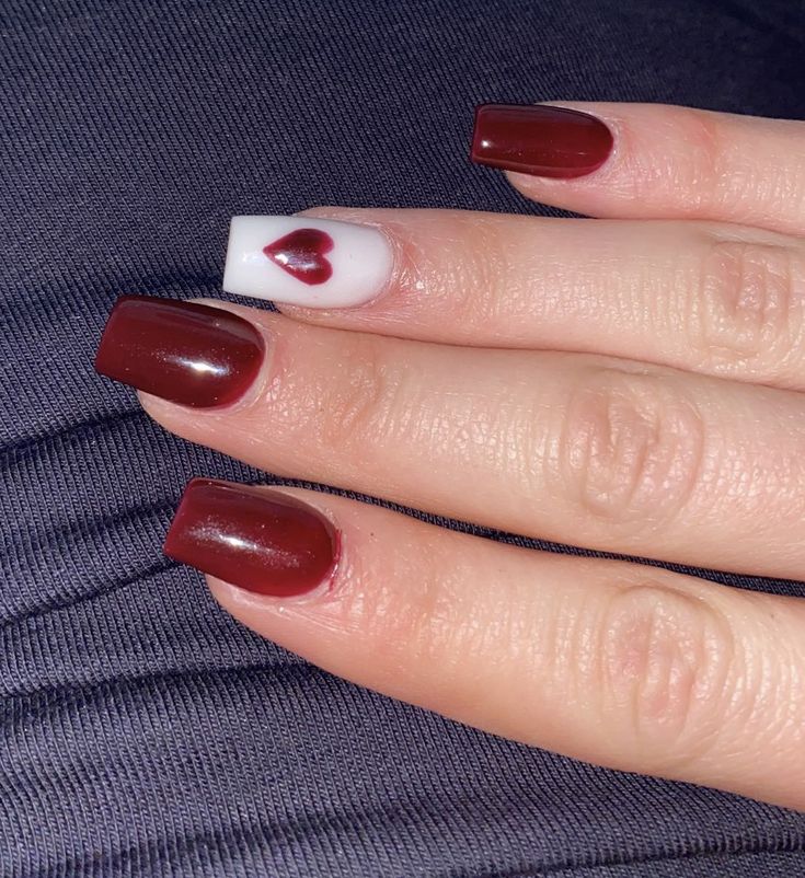 Chic Burgundy Nail Designs with Whimsical Heart Accent for Elegant Style.