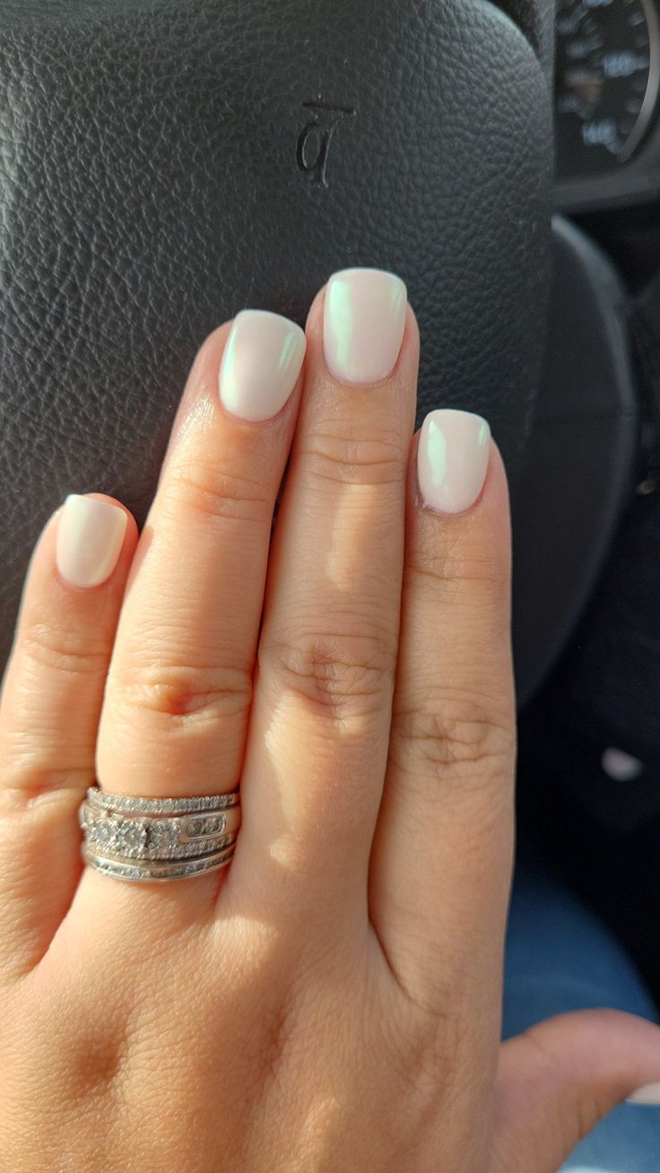 Sophisticated Milky White Manicure with Sparkling Accents.