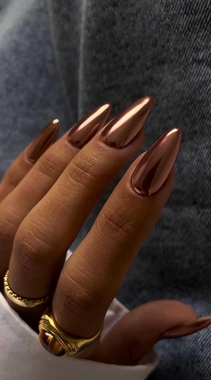 Sophisticated Metallic Rose Gold Almond Nail Design with Delicate Gold Accents.