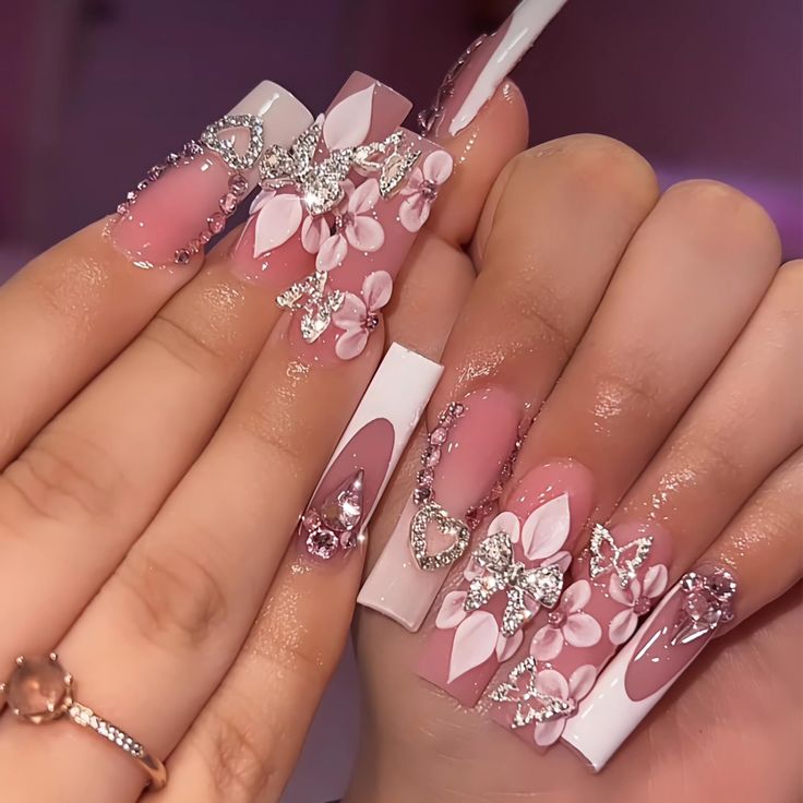 Elegant Coffin Nail Design with Soft Pink and White Shades, Floral Embellishments, and Sparkling Rhinestones.