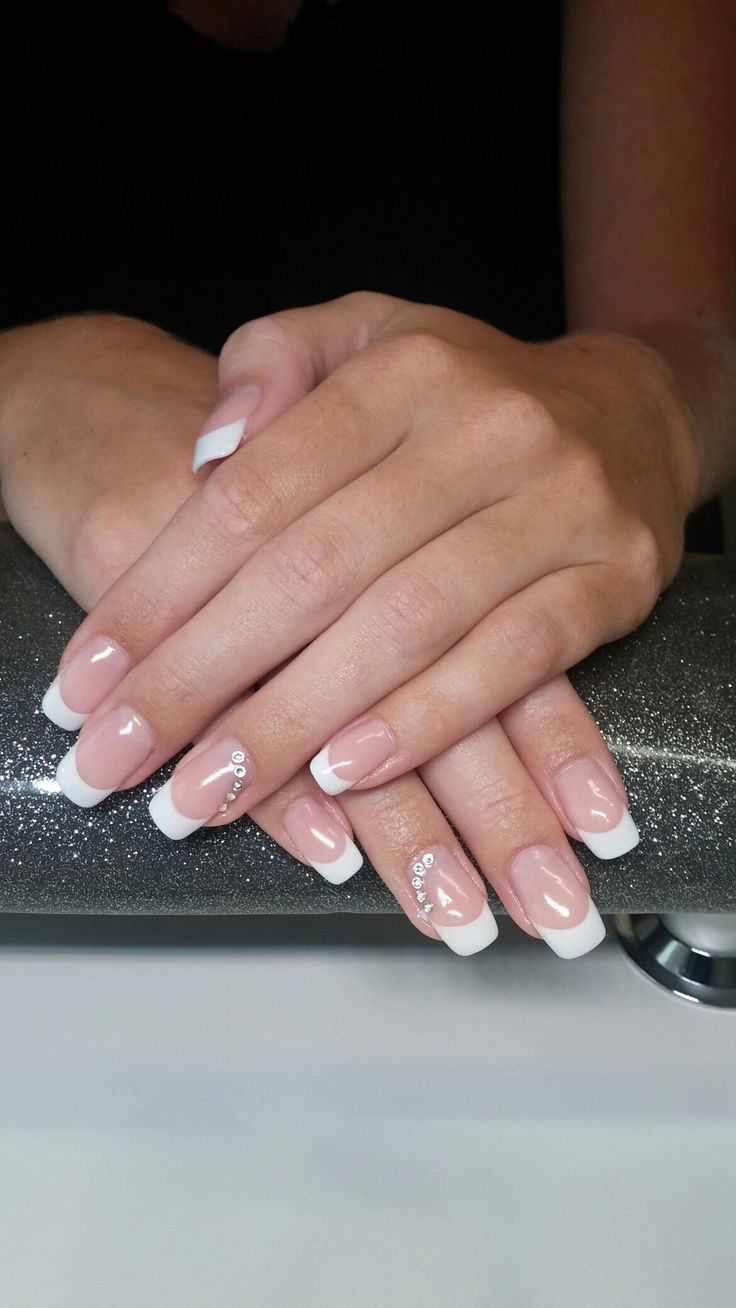 Sophisticated French Manicure: Timeless Nude Base with Rhinestone Accents.