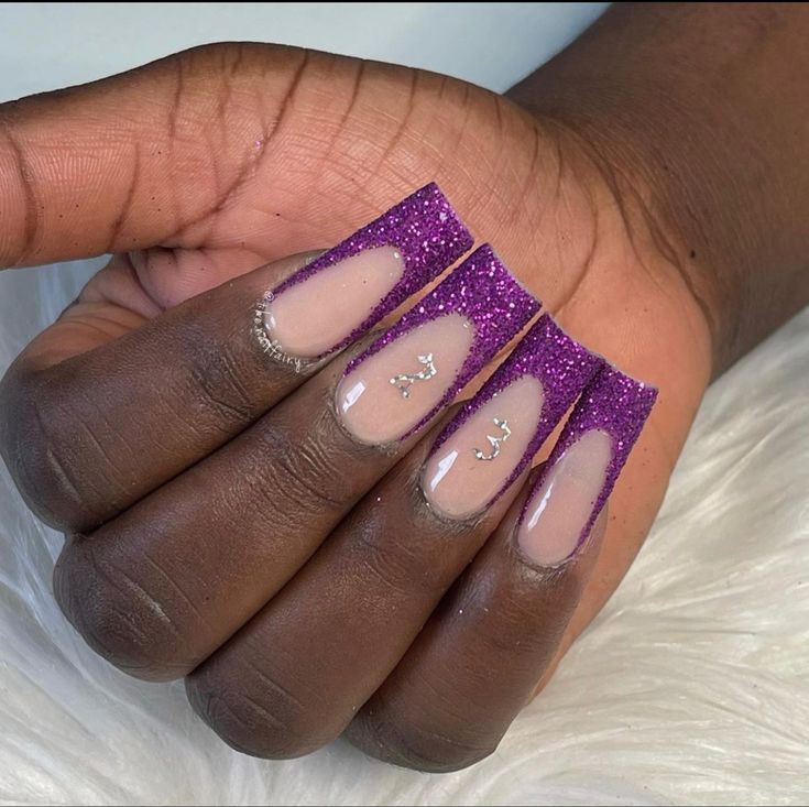 Elegant Purple Glitter Fade Nails with Nude Base and Subtle Embellishments.