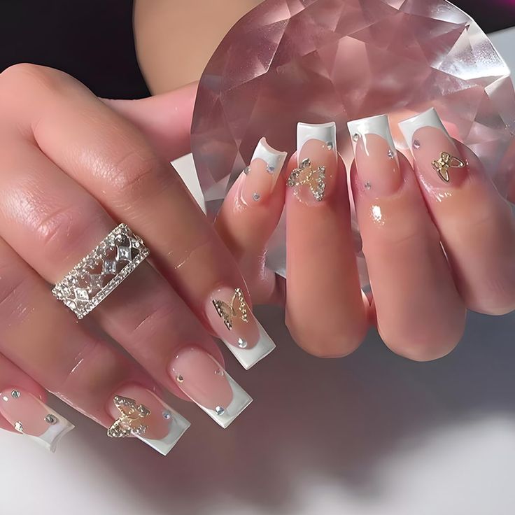 Chic French-Inspired Nail Design with Gold Butterfly Accents and Rhinestones