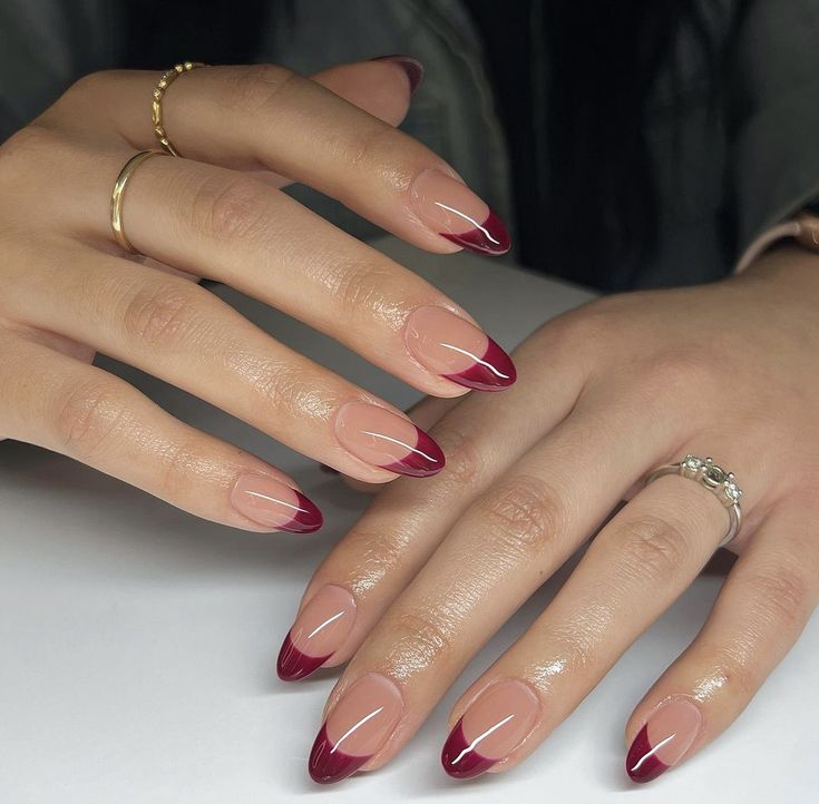 Sophisticated Dual-Toned Almond Nails: A Chic Blend of Nude and Deep Burgundy with Minimalist Accents.