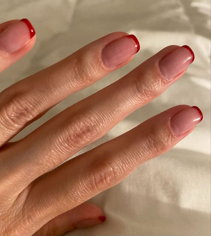 Chic Ombre Nude and Red Tip Manicure for a Playful, Modern Twist.