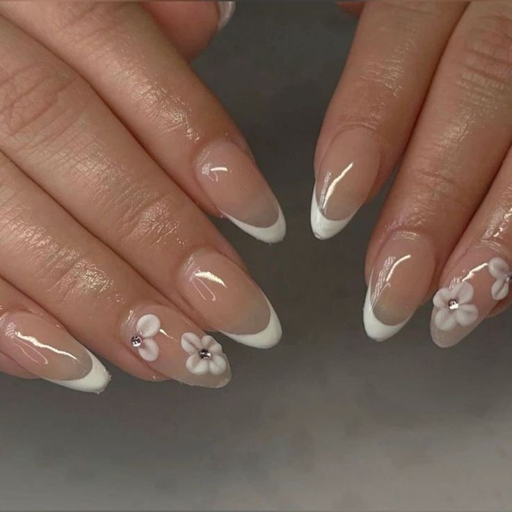 Sophisticated French Tip Manicure with Floral Accents and Glossy Finish.