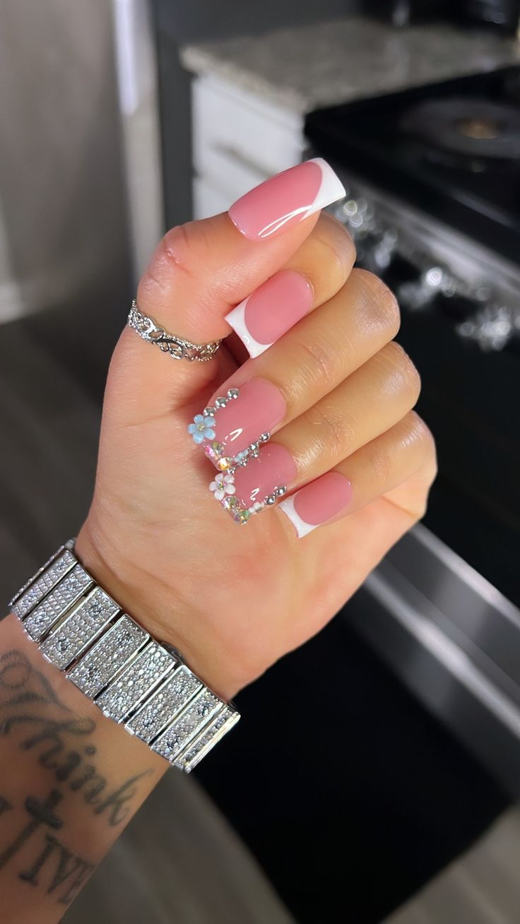 Chic Pink French Tip Manicure with Whimsical Floral Accents.