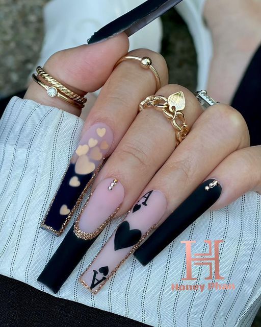 Elegant Almond Nail Design with Playful Motifs and Gold Accents.