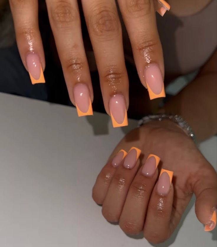 Elegant Nail Design: Soft Nude with Vibrant Orange Accents and Geometric Tips.