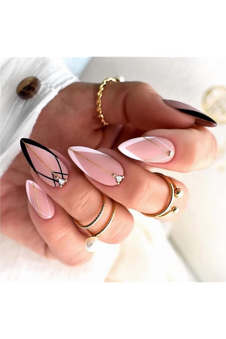 Chic and Modern Nail Design: Soft Pink with Black Accents and Gold Geometric Patterns.